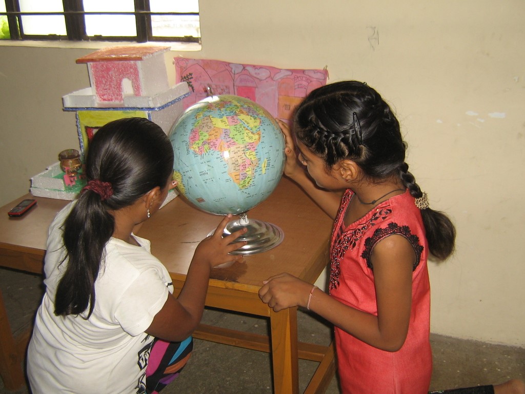 Nachiket readers examining a globe